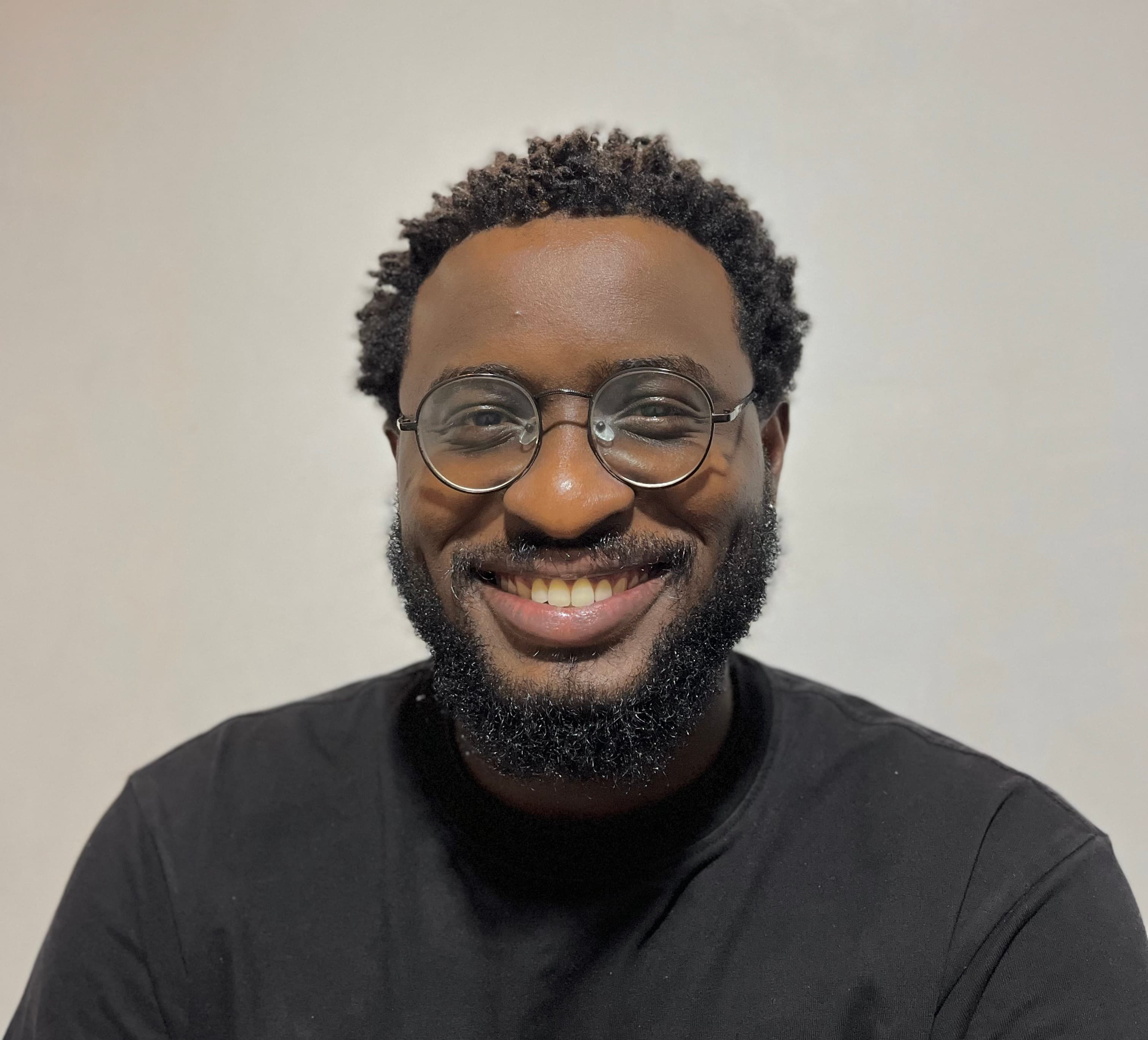 ayobami agunroye putting on a black shirt and smiling